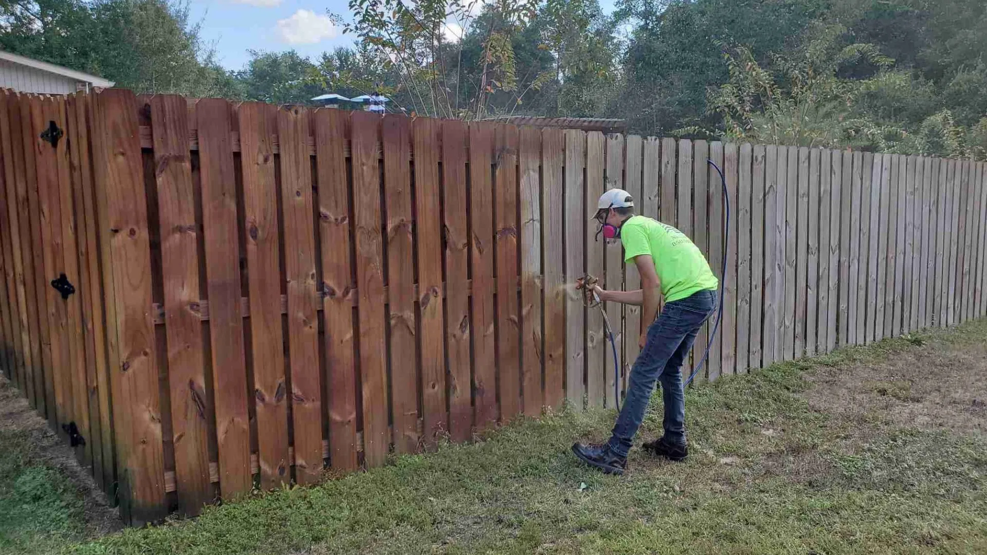 A wood fence being stained